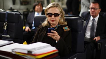 Former Secretary of State Hillary Clinton using her phone on a flight to Libya, in a picture that became widely popular. (Reuters)