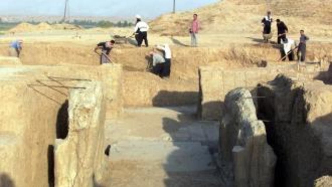 A file picture taken on July 17, 2001 shows Iraqi workers cleaning a statue of winged bull at an archeological site in Nimrud. (AFP)