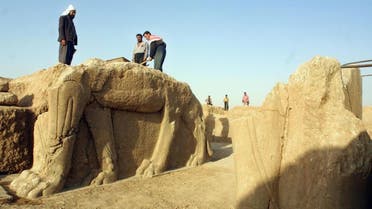 A file picture taken on July 17, 2001 shows Iraqi workers cleaning a statue of winged bull at an archeological site in Nimrud. (AFP)