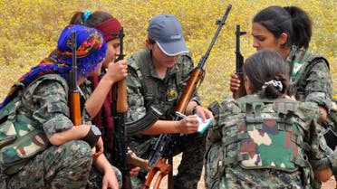 Kurdish female fighters of the Women Protection Unit (YPJ) squat as they discuss military strategies at a training field near Qamishli.(Reuters)
