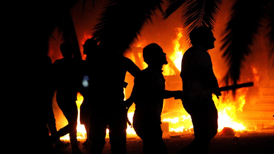 In this file photo, Libyan civilians watch fires at an Ansar al-Shariah Brigades compound. (AP)