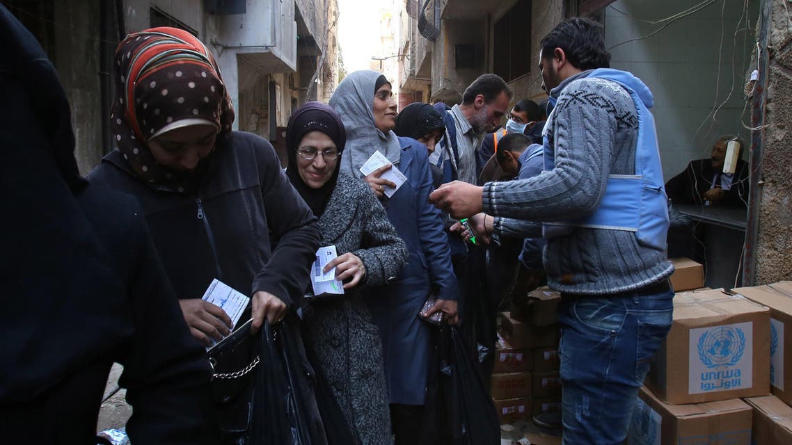 سكان من مخيم اليرموك يتلقون مساعدات الأمم المتحدة