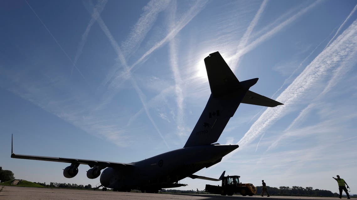 Members of Canadian air forces load ammunition into a plane AP