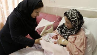 An Iranian nurse gives one-day-old baby girl to her mother at a hospital in Tehran AP 
