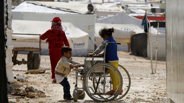 Syrian refugee children play with a wheelchair at the Al Zaatari refugee camp in the Jordanian city of Mafraq, near the border with Syria March 11, 2015. (Reuters)