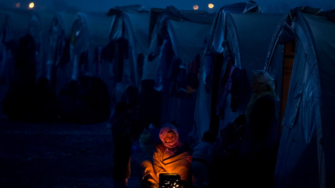 An elderly Syrian Kurdish refugee woman from the Kobane area, warms up by a fire at a camp in Suruc, on the Turkey-Syria border Monday, Nov. 10, 2014. (AP)