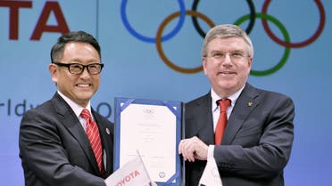 International Olympic Committee (IOC) President Thomas Bach and Toyota Motor Co. President Akio Toyoda hold their agreement document to become part of the IOC's top sponsorship programme (TOP) in Tokyo March 13, 2015. (Reuters)