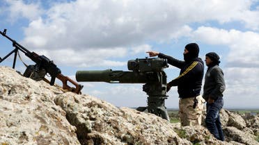 A rebel fighter of the Southern Front of the Free Syrian Army gestures while standing with his fellow fighter near their weapons at the front line in the north-west countryside of Deraa March 3, 2015. (Reuters)