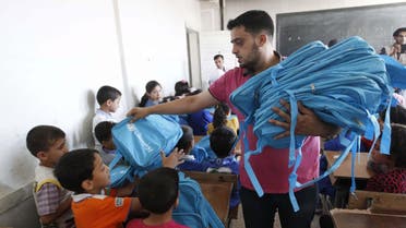 A man distributes bags donated from UNICEF to young students in Raqqa, now an ISIS-stronghold, on Sept 29, 2013. (File photo: Reuters)