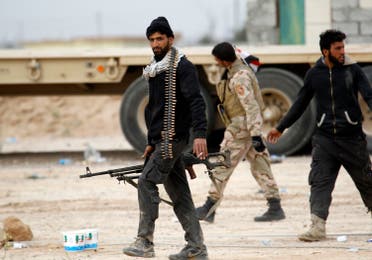 Shi'ite fighters known as Hashid Shaabi walk with their weapons on the southern edge of Tikrit March 12, 2015. (Reuters)