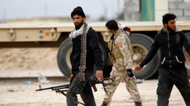 Shi'ite fighters known as Hashid Shaabi walk with their weapons on the southern edge of Tikrit March 12, 2015. (Reuters)
