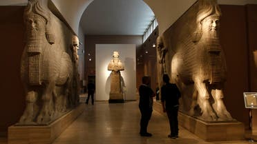 People look at ancient Assyrian human-headed winged bull statues at the Iraqi National Museum in Baghdad March 8, 2015. REUTERS