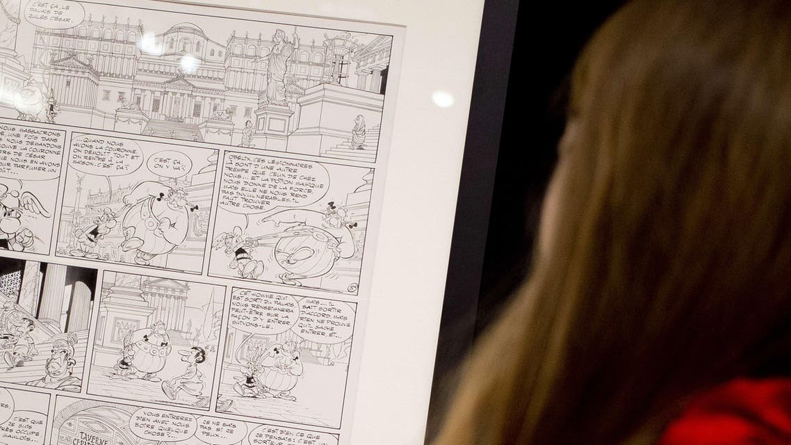 A picture taken on March 14, 2015 shows a visitor watching the original drawing of the Asterix 1972 comic book "Les lauriers de César" (Asterix and the Laurel Wreath), displayed at Christie's auction house in Paris. (AFP)