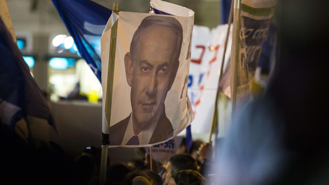 Supporters of Israeli Prime Minister and Likud party's candidate running for general elections, Benjamin Netanyahu, carry posters bearing his portrait during his campaign meeting on March 15, 2015, AFP