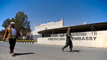 Houthi Yemenis walk past the gate of the main entrance of the closed U.S. embassy after Yemeni police opened the road in front of it, in Sanaa, Yemen, Wednesday, March 4, 2015. AP