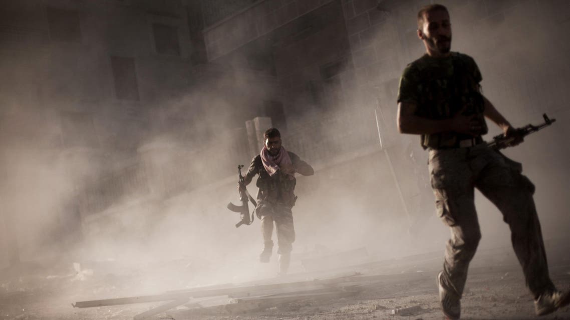 In this Friday, Sept 7, 2012 file photo, free Syrian Army fighters run after attacking a Syrian Army tank during fighting in the Izaa district in Aleppo, Syria. (AP)