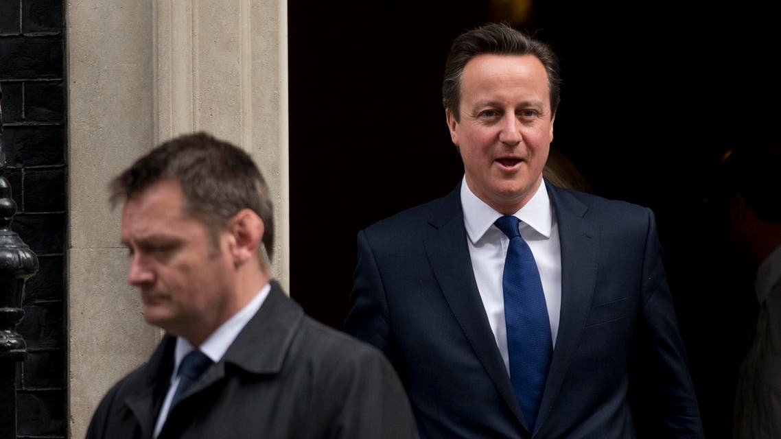 British Prime Minister David Cameron walks to get in a car flanked by a security officer as he leaves 10 Downing Street in London, on March 25, 2015. (AP)