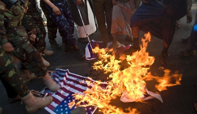  Yemeni protesters burn representations of an American flag during a demonstration to show their support for Houthi Shi'ite rebels in Sanaa, Yemen, Jan. 23, 2015. (AP)