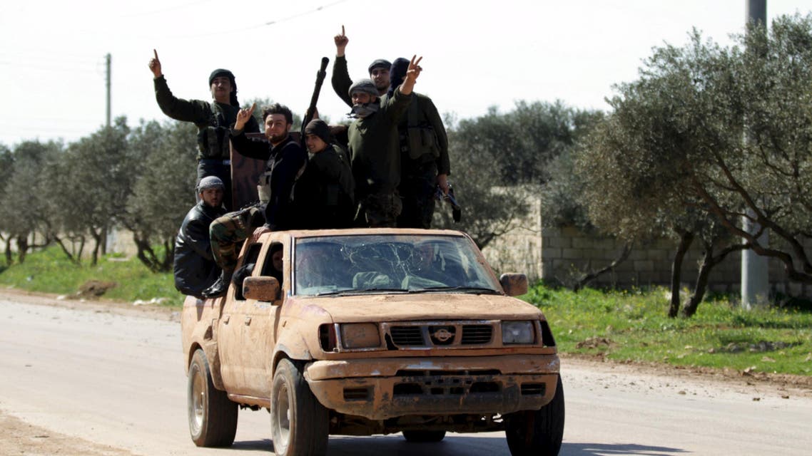 Ahrar al-Sham Islamic Movement rebel fighters ride on the back of a pick-up truck in the northwestern city of Idlib March 26, 2015. Reuters