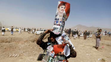 A woman supporting Ahmed Ali Abdullah Saleh, the son of Yemen's former President Ali Abdullah Saleh, wears posters of the Salehs at site of a demonstration demanding for a presidential election to be held and for Ahmed to run for presidency, in Sanaa, March 13, 2015. 