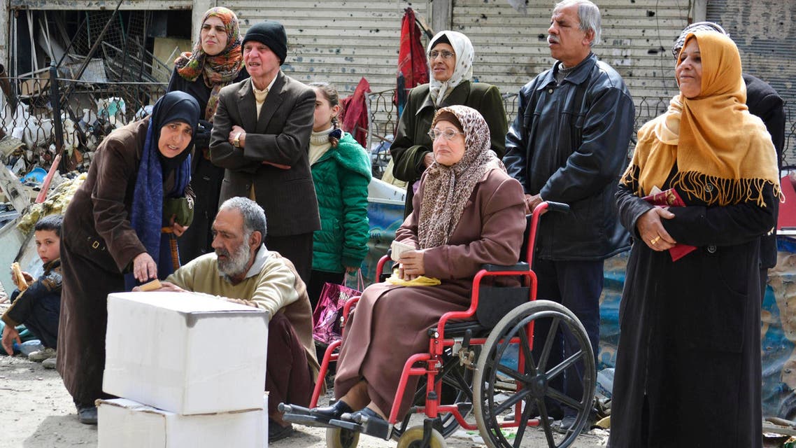 Residents wait to receive humanitarian aid at the Palestinian refugee camp of Yarmouk, in Damascus March 11, 2015. (Reuters)