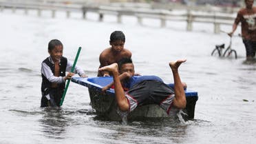 Filipino children play with a bathtub along flooded roads as Typhoon Rammasun batters suburban Navotas, Philippines on, July 16, 2014. (AP) 