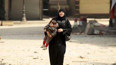 A woman carrying a child reacts at a damaged site after what activists said was shelling by forces loyal to Syria's president Bashar al-Assad on a mosque in Idlib city, after rebels took control of the area April 3, 2015. Reuters 