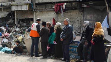 سكان من مخيم اليرموك ينتظرون لاستلام مساعدات إنسانية