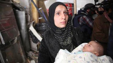 A woman holds a baby at the Yarmouk refugee camp in this March 10, 2015 picture provided by UNRWA. (File: Reuters)