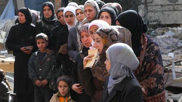 People wait to collect food aid distributed by UNRWA at the Yarmouk refugee camp. (Reuters)