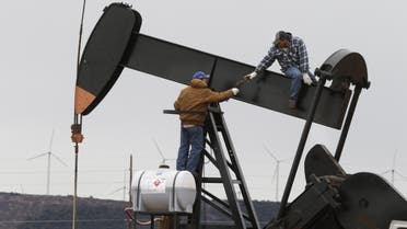 In this photo made Tuesday, Dec. 23, 2014, men work on an well pump near Sweetwater, Texas. At the heart of the Cline, a shale formation once thought to hold more oil than Saudi Arabia, Sweetwater is bracing for layoffs and budget cuts, anxious as oil prices fall and its largest investors pull back. (AP Photo/LM Otero)