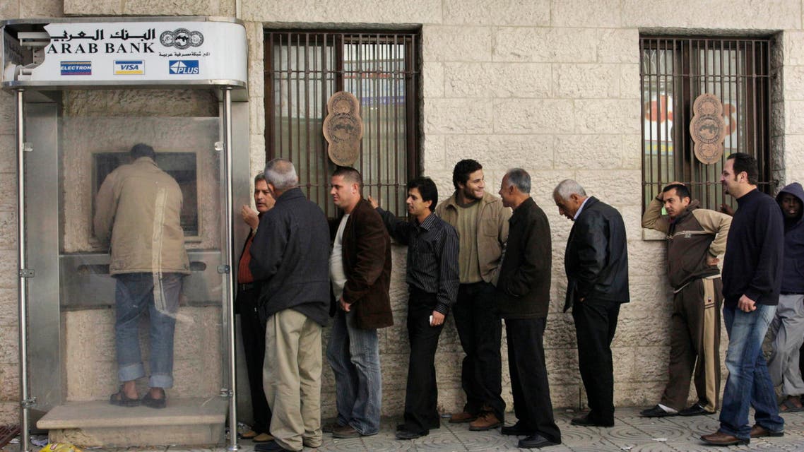 Palestinians wait to take money from a bank machine at an Arab Bank branch in Gaza City, Friday, Dec. 12, 2008. (File: AP)