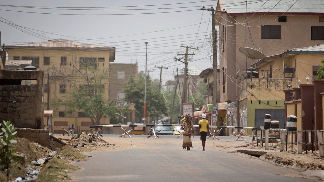 Two women walk down a deserted street with roadblocks at the end leading to the St Charles Catholic Church, scene of a 2014 bomb attack blamed on Boko Haram Islamic insurgents, in the mainly Christian Sabon Gari neighborhood of Kano, northern Nigeria on Palm Sunday, March 29, 2015. Normally the church would be packed with up to four masses on Palm Sunday, but this year it held only one which was half-full, due to large numbers of Christians leaving before the elections, fearing violence and retribution after election results will be announced in the predominantly Muslim town. (AP Photo/Ben Curtis)