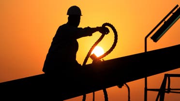 An unidentified oilfield worker ties pipes to be raised on an oil rig as the sun sets Wednesday, July 7, 2010, in the Persian Gulf desert oil field of Sakhir, Bahrain.(File photo: AP)