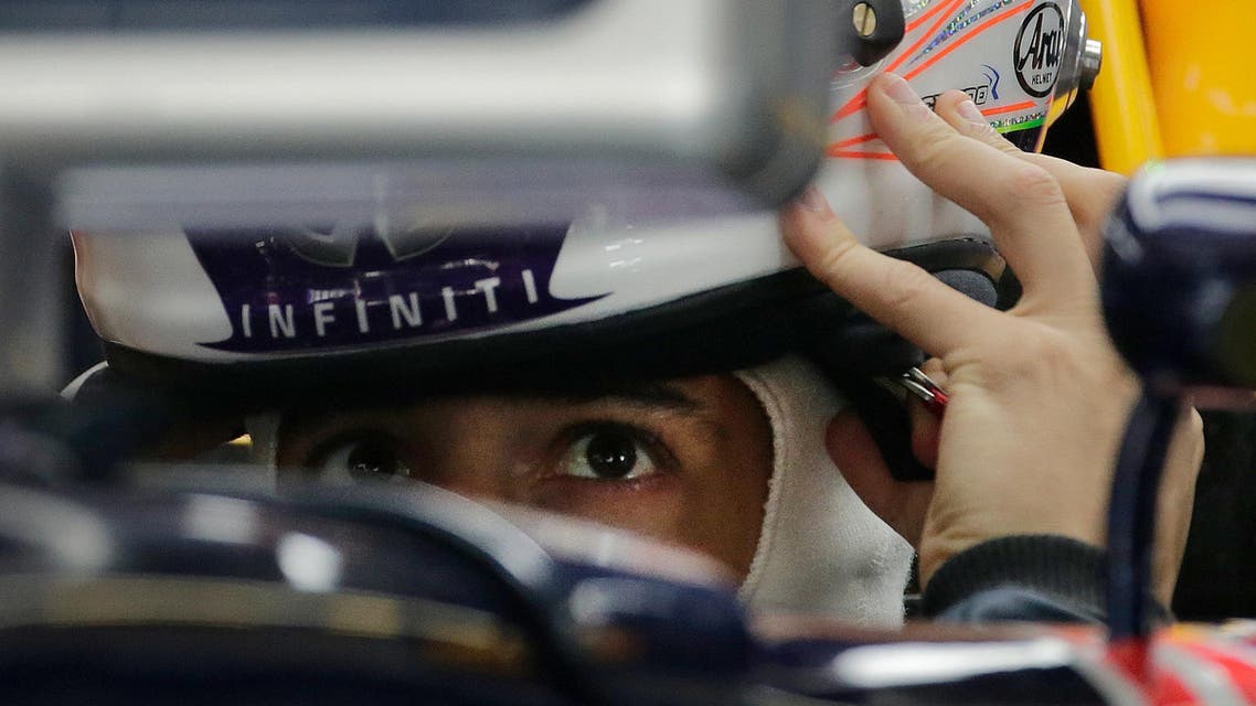 Red Bull driver Daniel Ricciardo of Australia puts on his helmet as he prepares for the first practice session for the Chinese Formula One Grand Prix at Shanghai International Circuit in Shanghai, China, Friday, April 10, 2015. (AP Photo/Andy Wong)