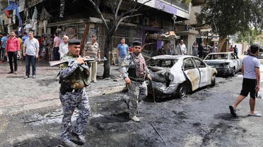 People and security forces gather at the site of a car bomb explosion at a convenience store in the Karrada neighborhood of Baghdad, Iraq, Friday, April 10, 2015. Iraqi officials say the blast in the downtown district killed several people and wounded a dozen. (AP Photo/ Karim Kadim)