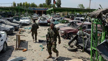 Afghan security personnel walk through the site of a suicide car bomb attack targeting a NATO convoy near the airport in Jalalabad on April 10, 2015.  (AFP)