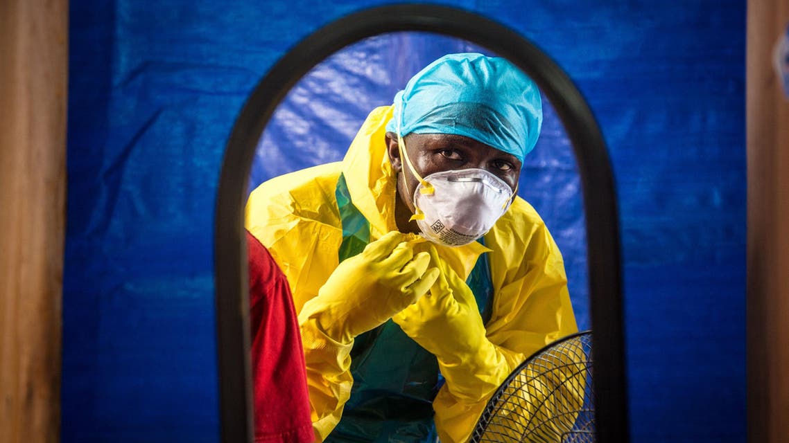 In this Thursday, Oct. 16, 2014 file photo, a healthcare worker dons in protective gear before entering an Ebola treatment center in the west of Freetown, Sierra Leone. Professors from three leading British universities say policies favoring international debt repayment over social spending contributed to the Ebola crisis by hampering health care in the three worst-hit West African countries. Conditions for loans from the International Monetary Fund prevented an effective response to the outbreak that has killed nearly 8,000 people, the academics allege in a report in The Lancet Global Health journal this month. (AP Photo/Michael Duff, File)