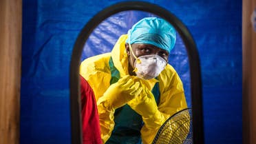 In this Thursday, Oct. 16, 2014 file photo, a healthcare worker dons in protective gear before entering an Ebola treatment center in the west of Freetown, Sierra Leone. Professors from three leading British universities say policies favoring international debt repayment over social spending contributed to the Ebola crisis by hampering health care in the three worst-hit West African countries. Conditions for loans from the International Monetary Fund prevented an effective response to the outbreak that has killed nearly 8,000 people, the academics allege in a report in The Lancet Global Health journal this month. (AP Photo/Michael Duff, File)