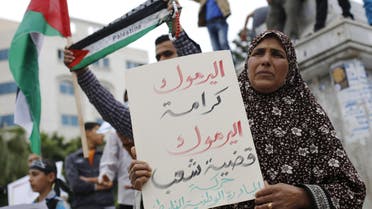  A Palestinian woman holds a placard during a gathering in Gaza City on April 9, 2015, in solidarity with the Palestinians living in Syria's Yarmuk refugee camp. (File: AFP)