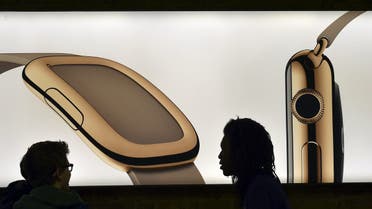 A customer and a staff member speak in front of a sample Apple Watch on a lightbox advertisement photograph at the Apple Store in London Reuters 