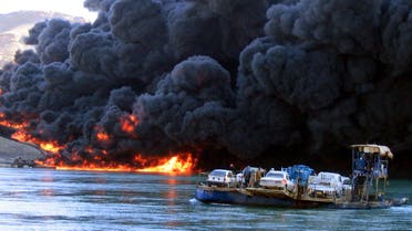 A car ferry crosses the Tigris river outside Baiji, some 250 kilometers (150 miles) north of Baghdad Tuesday, Dec 21 2004 as an oil pipeline burns on the other bank. (