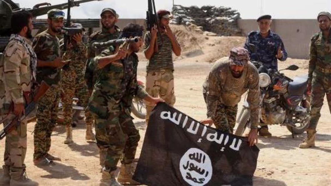 raqi security forces hold a flag of the Islamic State group they captured during an operation outside Amirli, some 105 miles north of Baghdad, Iraq. Reuters