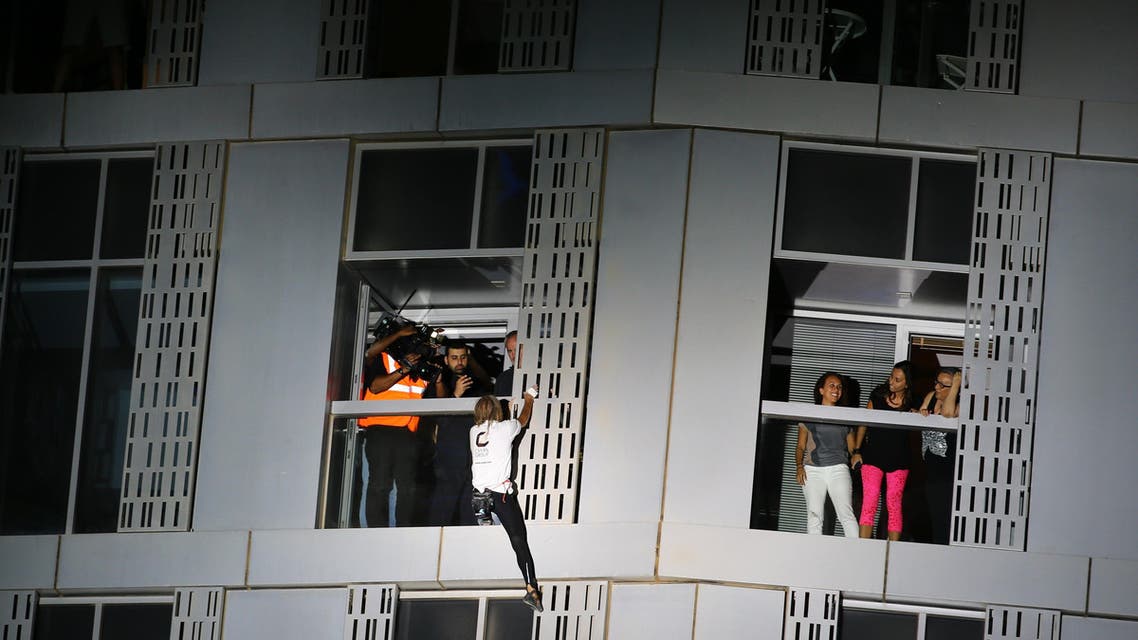 French urban climber Alain Robert, also known as "Spider-Man", scales the Cayan Tower, the world's tallest twisted building, on April 12, 2015 in Dubai. (AFP)