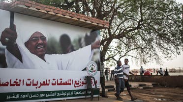 In this Saturday, April 11, 2015 photo, Sudanese boys walk past an election campaign banner in support of President Omar al-Bashir, in Khartoum, Sudan, that reads "community commission in support of nominating Marshal Omar al-Bashir." (AP)