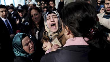 A wife and mother of a slain miner react as police block the gate on April 13, 2015 to a special tribunal set up in a cultural center in Akhisar in western Turkey before a trial over 301 miners killed last year. Dozens of suspects will stand trial on April 13 in Akhisar, some 40 kms (25 miles) from the coal mining town of Soma where the disaster took place in May. Forty-five people are to stand trial, including eight former top managers from the Soma Komur group that ran the mine who have been accused of murder over the deaths of the miners, Turkey's worst ever mining disaster. AFP PHOTO / OZAN KOSE