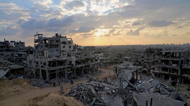 Palestinians walk during the sunset between the rubble of their destroyed building in Shijaiyah neighborhood of Gaza City in the northern Gaza Strip, Sunday, Oct. 12, 2014. (AP)