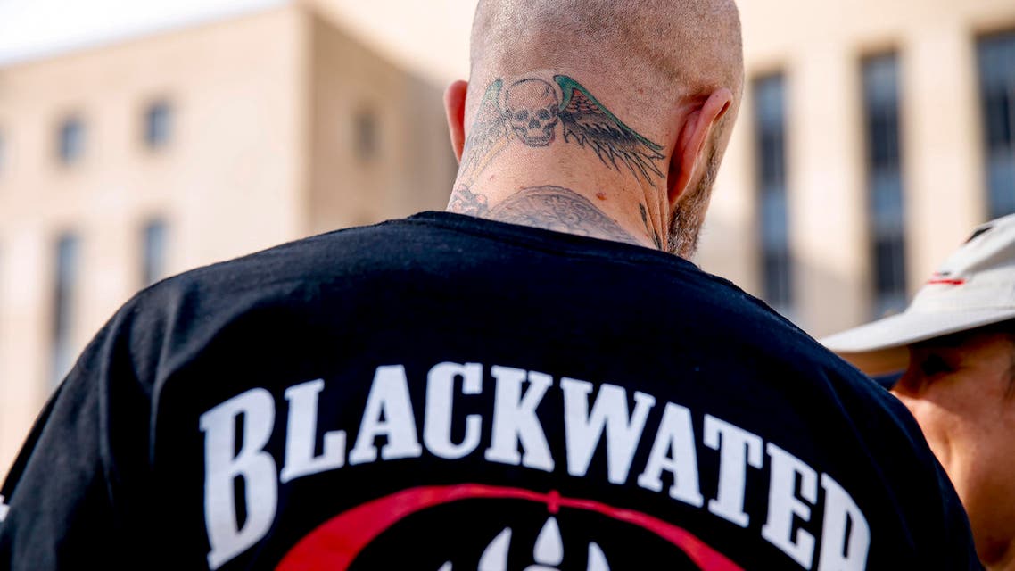 A former member of Blackwater joines family members, friends, and supporters of four former Blackwater security guards outside the federal court in Washington, Monday, April 13, 2015, following sentencing for four former Blackwater security guards in connection with a 2007 shooting of civilians in Iraq. U.S. District Judge Royce Lamberth sentenced Nicholas Slatten to life in prison while Paul Slough of Keller, Texas, Evan Liberty of Rochester, N.H., and Dustin Heard of Knoxville, Tenn., were convicted of manslaughter and received sentences of 30 years plus one day. (AP Photo/Andrew Harnik)