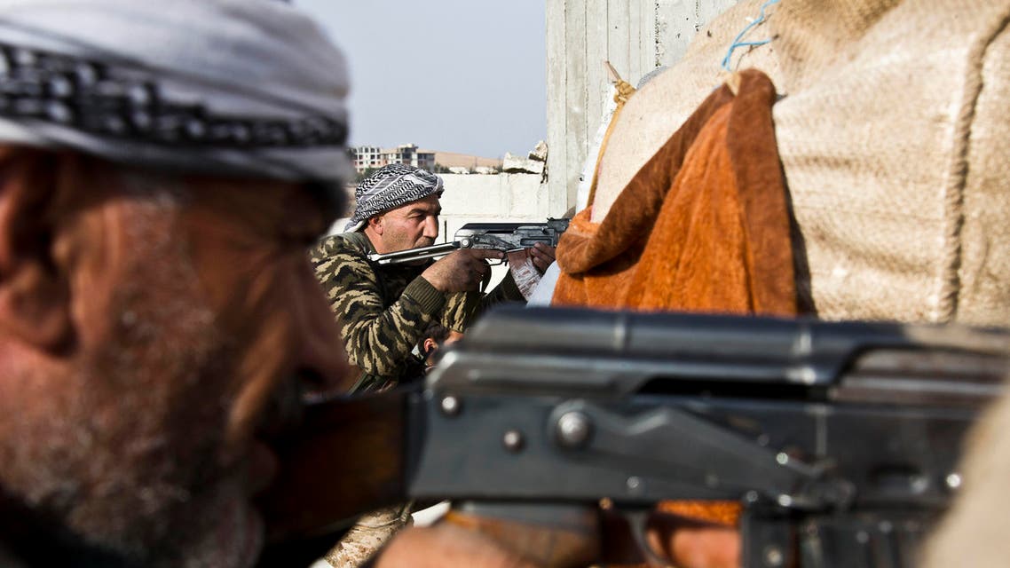 In this Nov. 19, 2014 file photo, fighters from the Free Syrian Army, left, and the Kurdish People's Protection Units, center, join forces to fight Islamic State group militants in Kobani, Syria. Kurdish fighters in Syria have ambitions to become the chief force fighting Islamic State group extremists in the country - building on their victory in Kobani to ally with moderate rebels and push the jihadis ever further. They tout the alliance as a gamechanger in the Syria war as well: the emergence of the effective moderate rebel force that the West has been looking to ally with all along. (AP Photo/Jake Simkin, File)