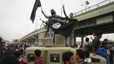 In this Sunday, March 30, 2014, file photo, Islamic State group militants hold up their flag as they patrol in a commandeered Iraqi military vehicle in Fallujah, 40 miles west of Baghdad, Iraq. (AP)